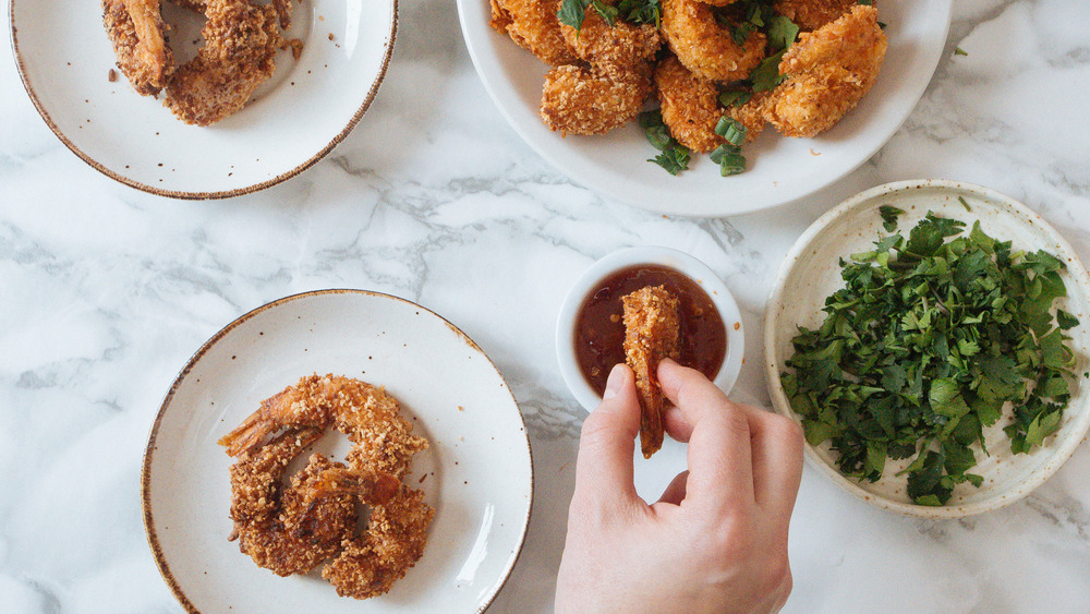 dipping shrimp into sauce