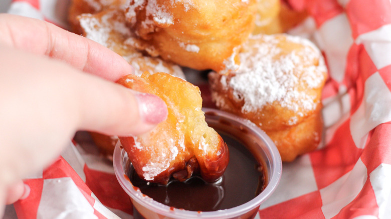 hand dipping funnel cake bites