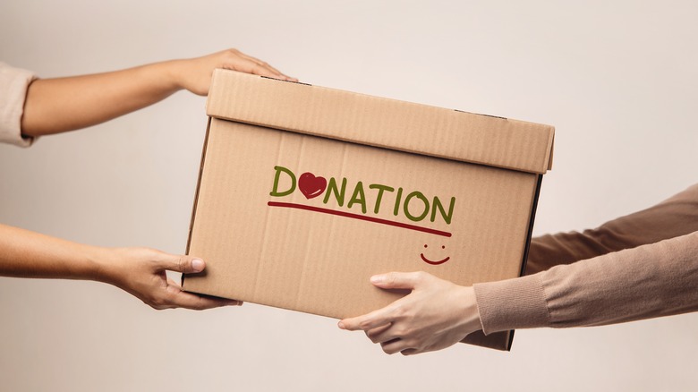 person handing over box of donations