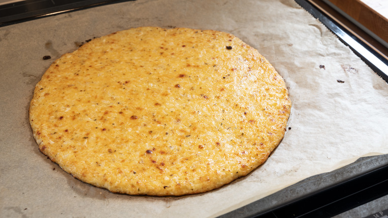 Cauliflower pizza crust on a baking sheet