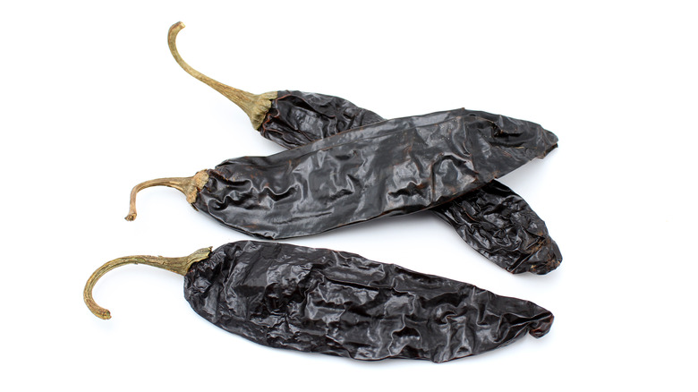 Dried pasilla chiles on white background