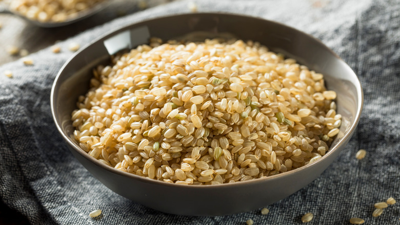 Grey bowl of raw brown rice