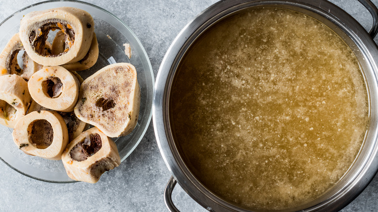 Cleaned beef bones next to pot of beef stock