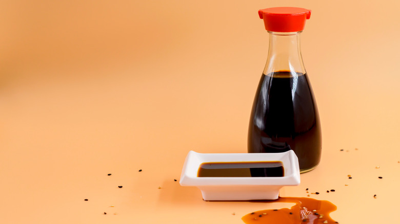 A bottle of soy sauce next to small dish