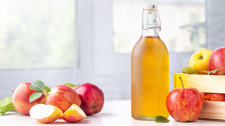 Apple juice in a glass bottle with apples