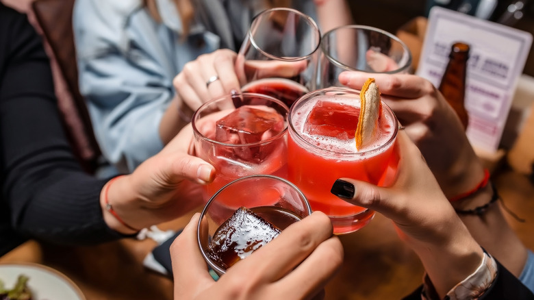 Friends toasting with red cocktails