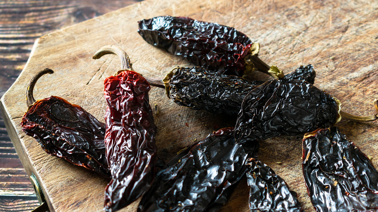 Wood tray of dark, dried chile peppers