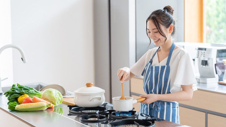 Woman standing up mixing sauce