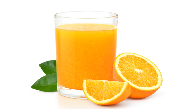 Glass of orange juice with sliced fresh orange