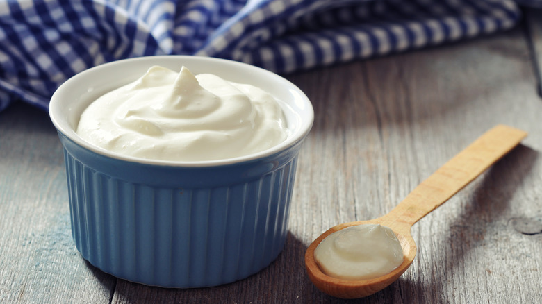 Plain yogurt in a blue bowl with spoon