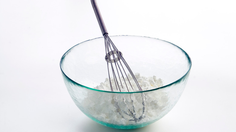 White flour in glass bowl with whisk