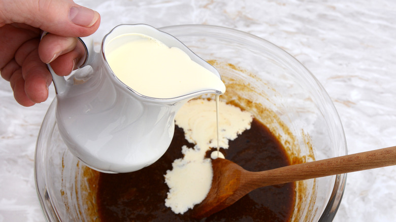 Heavy cream being poured into a mixing bowl