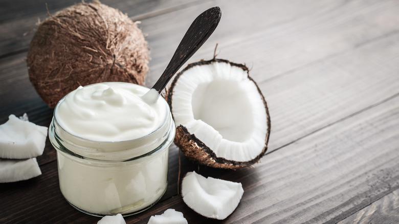 Coconut pieces next to a jar of coconut cream