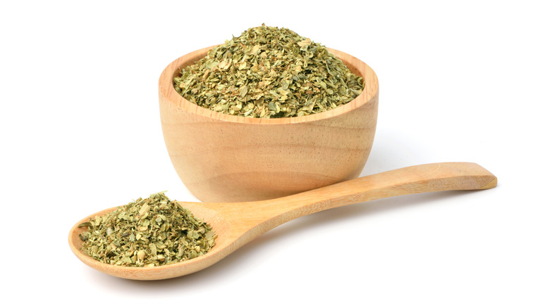 Dry herb seasoning mix in wooden bowl with spoon