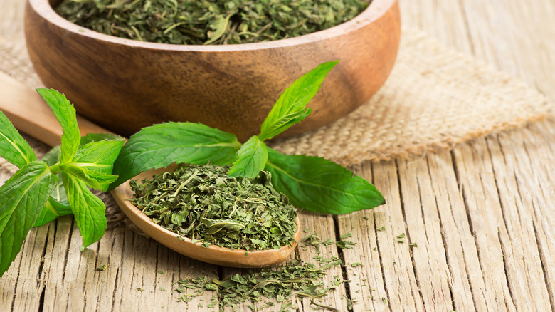 Dried herbs with mint leaves in wooden spoon