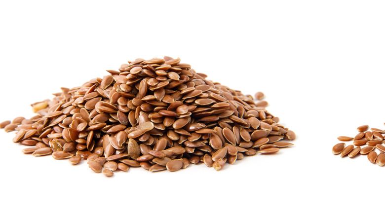 pile of raw flaxseeds on white background