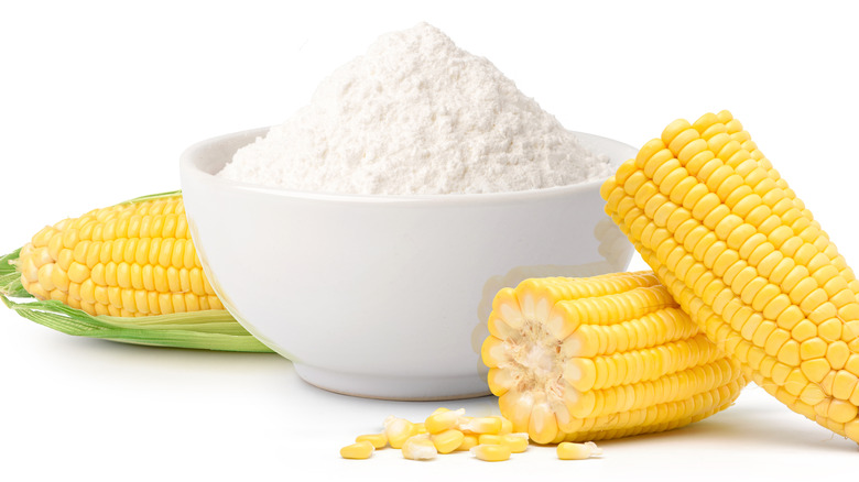 powdered cornstarch in white bowl next to corn cobs