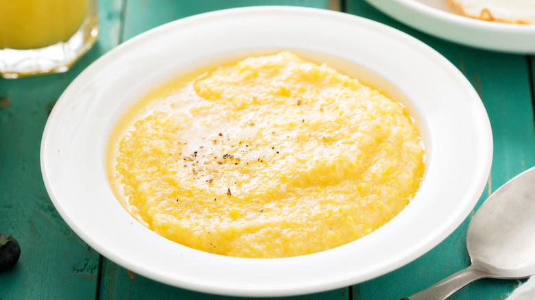 hominy grits in white bowl on green table