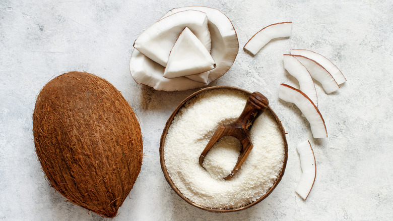 Coconut flour in a bowl next to coconuts