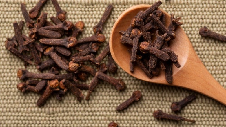 Whole cloves in wooden spoon on table