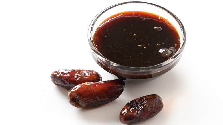 Dates next to a bowl of date syrup