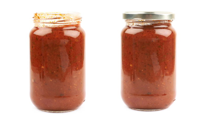 Jars of marinara sauce on white background 