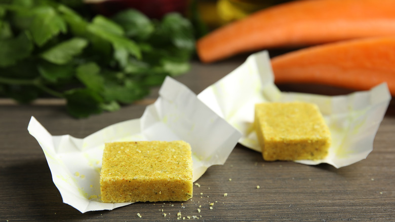 Bouillon cubes with vegetables in the background