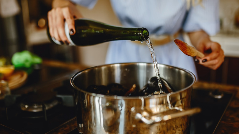 Woman adding wine to a pot