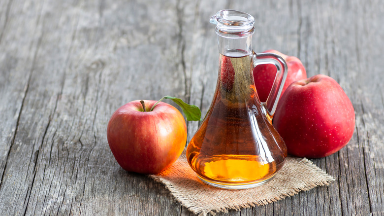 Apple cider vinegar next to apples