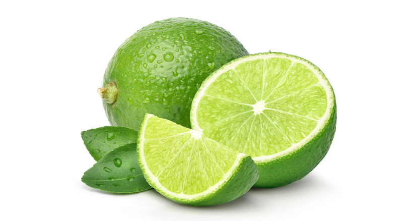 Whole lime next to cut wedges