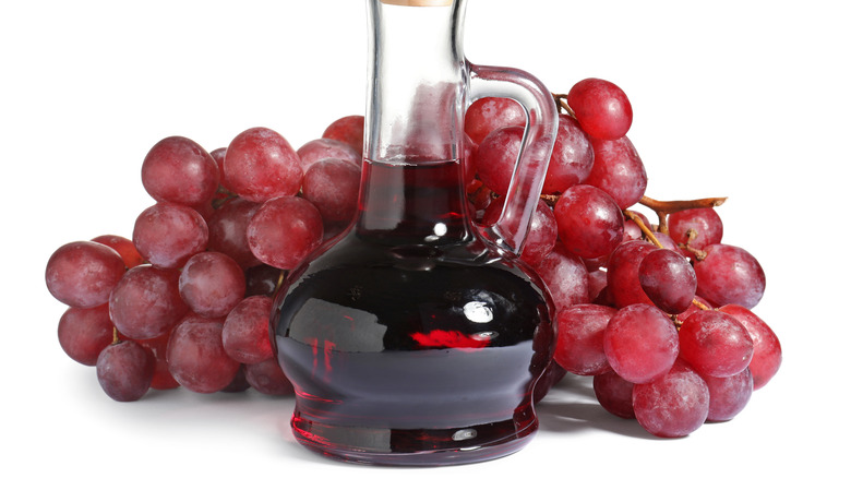 Red wine vinegar bottle next to grapes