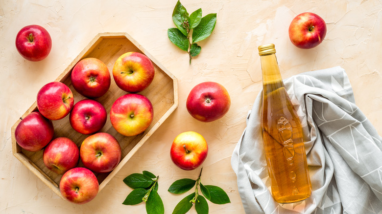 apple cider vinegar next to fresh apples