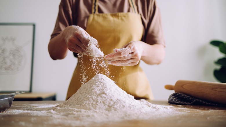 woman mixing flour yellow apron