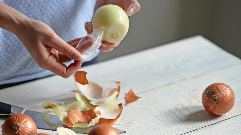 woman peeling onion skins