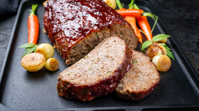 Meatloaf slices from loaf on pan