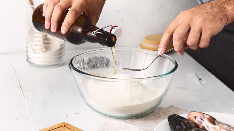 Person pouring beer into flour mixture bowl