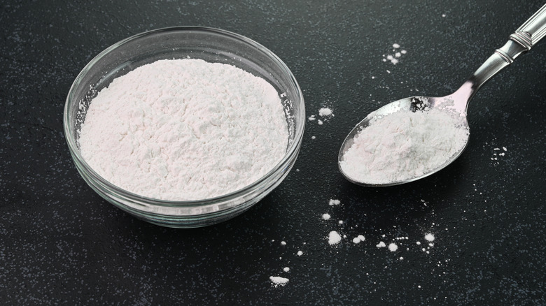 Baking powder in clear bowl with spoon