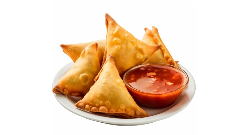 plate of samosas with dipping sauce