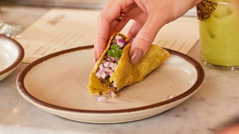 person picks up taco at Alma Fonda Fina