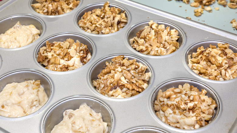 Muffin tin with batter and nuts