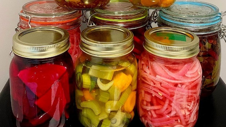 Several pickling jars with vegetables