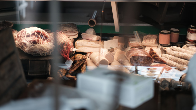 Cuts of meat are shown in a deli window.