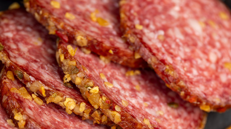 A closeup shows thickly cut salami slices.