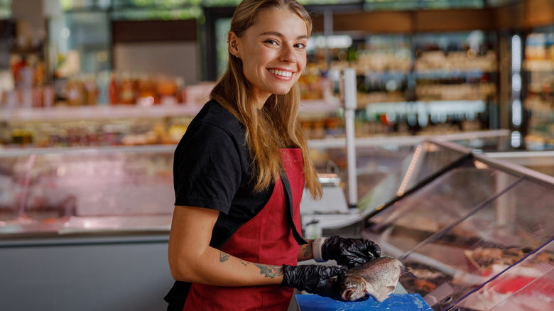 A worker smiling in a deli