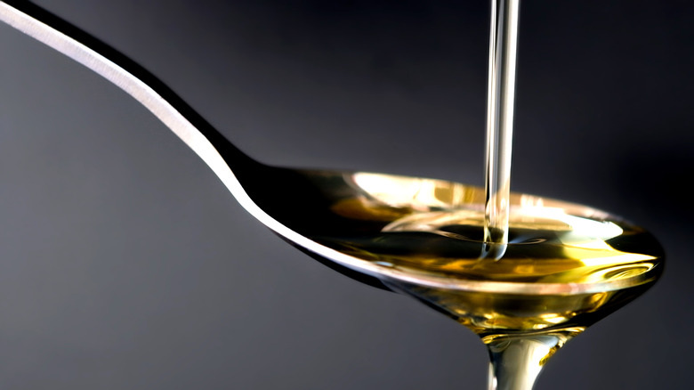 olive oil being poured onto a spoon