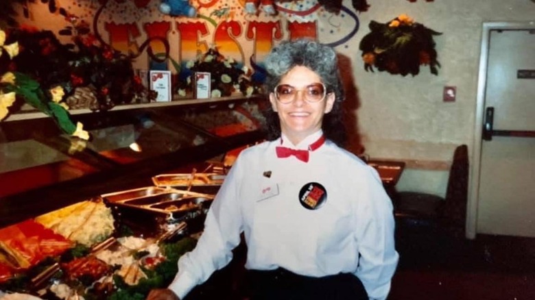 Chi-Chi's employee smiles in front of its buffet