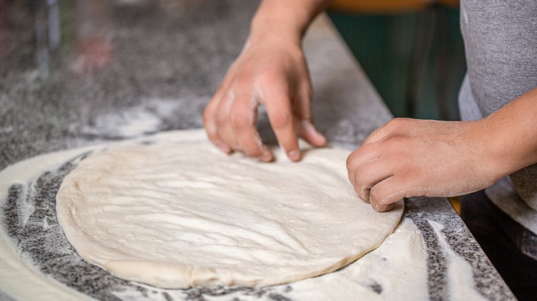 raw dough rolled out for pizza