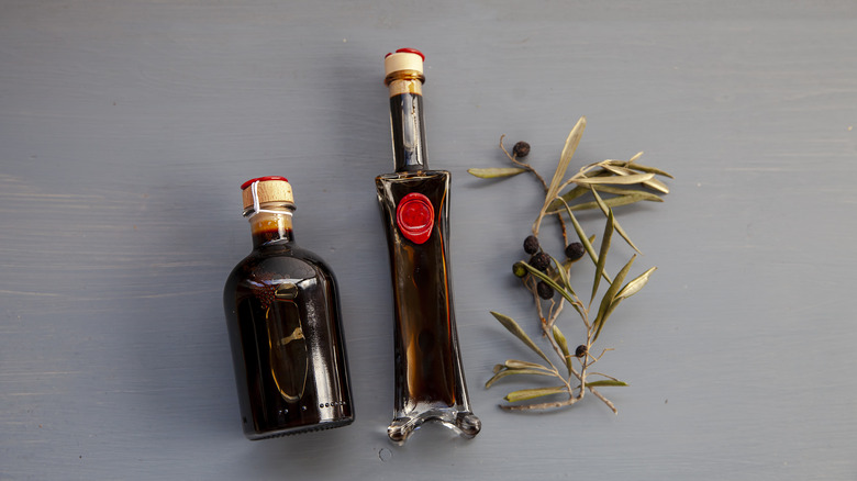 Bottles of balsamic vinegar with olive branches