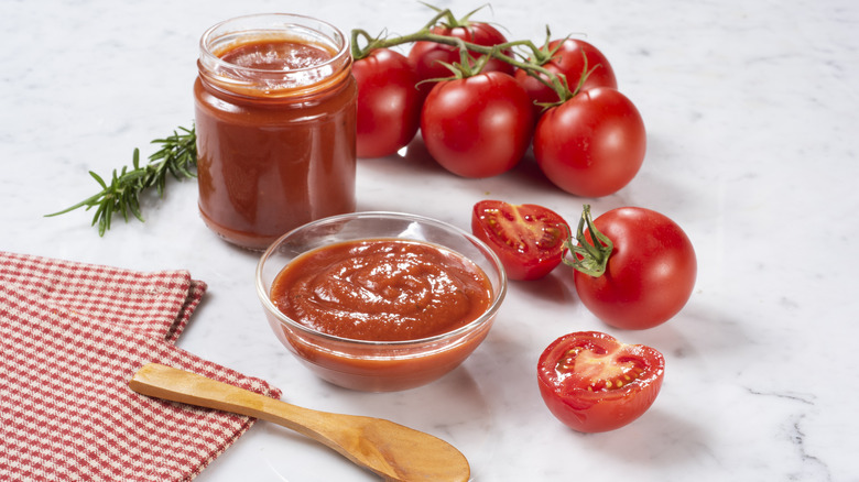 Tomato paste in bowl with tomatoes