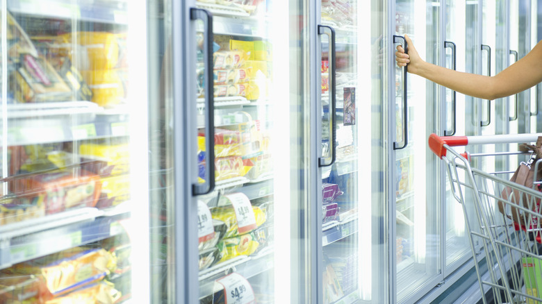 hand reaching for freezer door handle